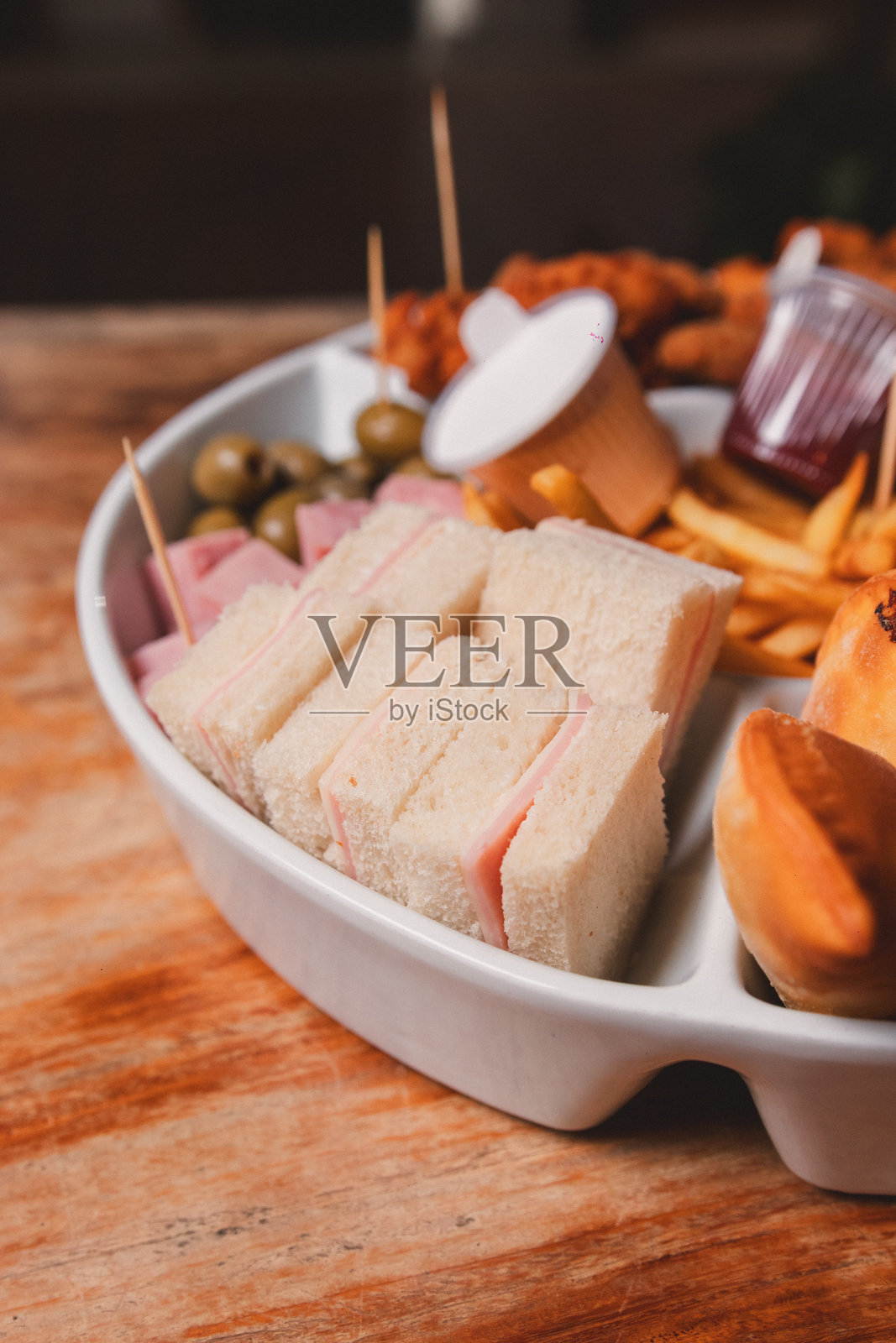 小型火腿奶酪三明治的特写视图，以及托盘上的各种小吃。照片摄影图片