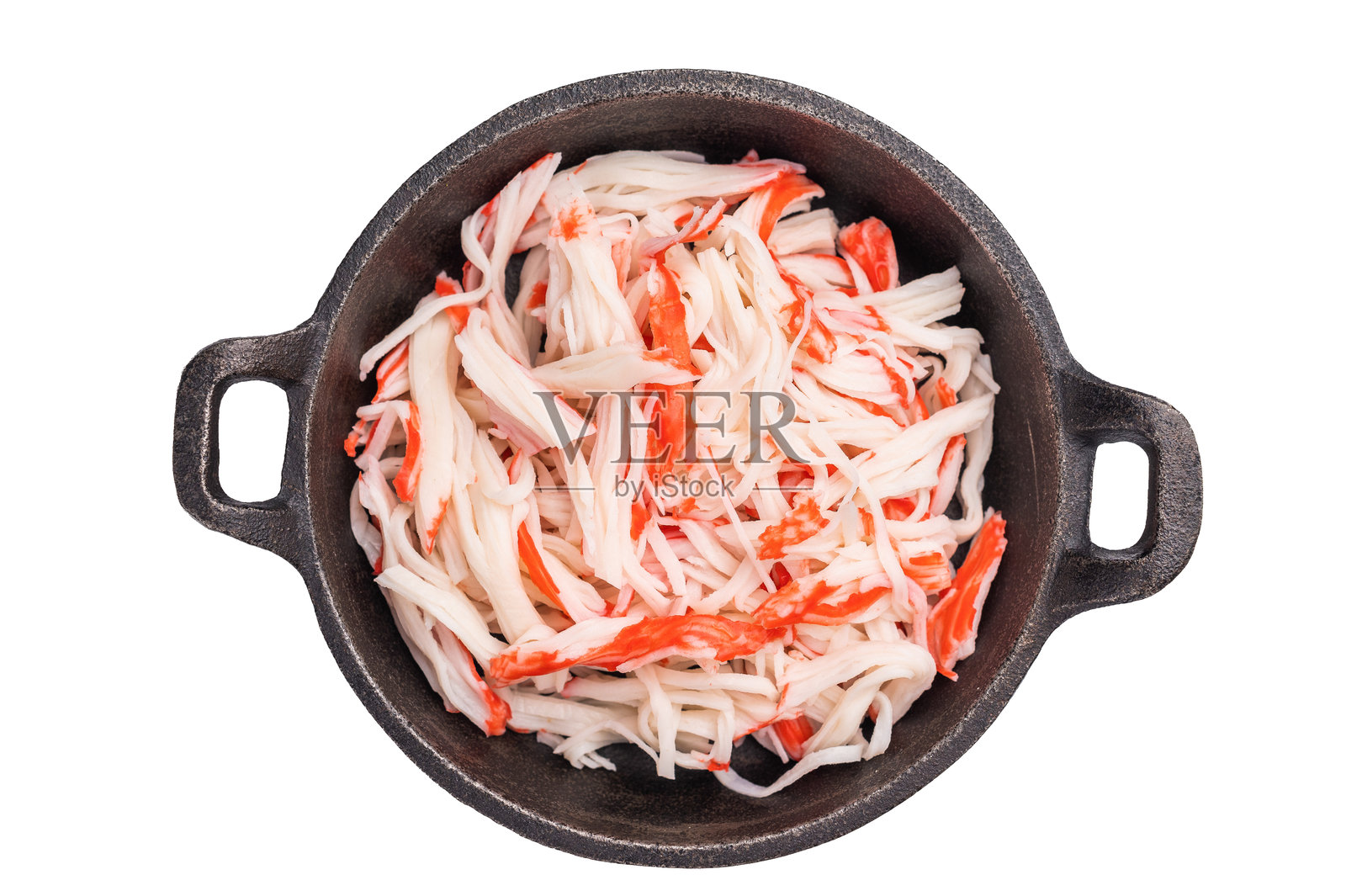 日本蟹肉，蟹肉仿制品在平底锅中，背景为白色。俯视图。照片摄影图片