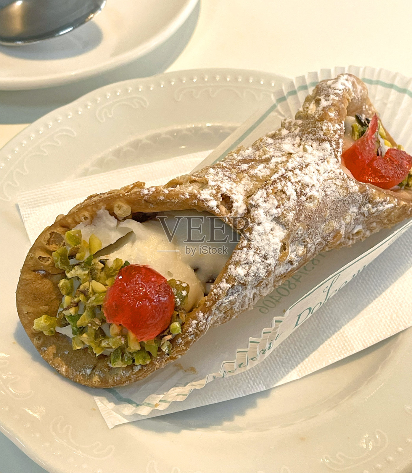 带有开心果的卡诺利放在小盘子上。照片摄影图片