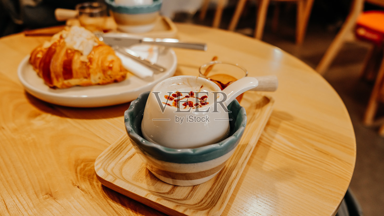 温馨的早晨享受：一杯完美冲泡的咖啡和酥脆的可颂面包放在木桌上照片摄影图片