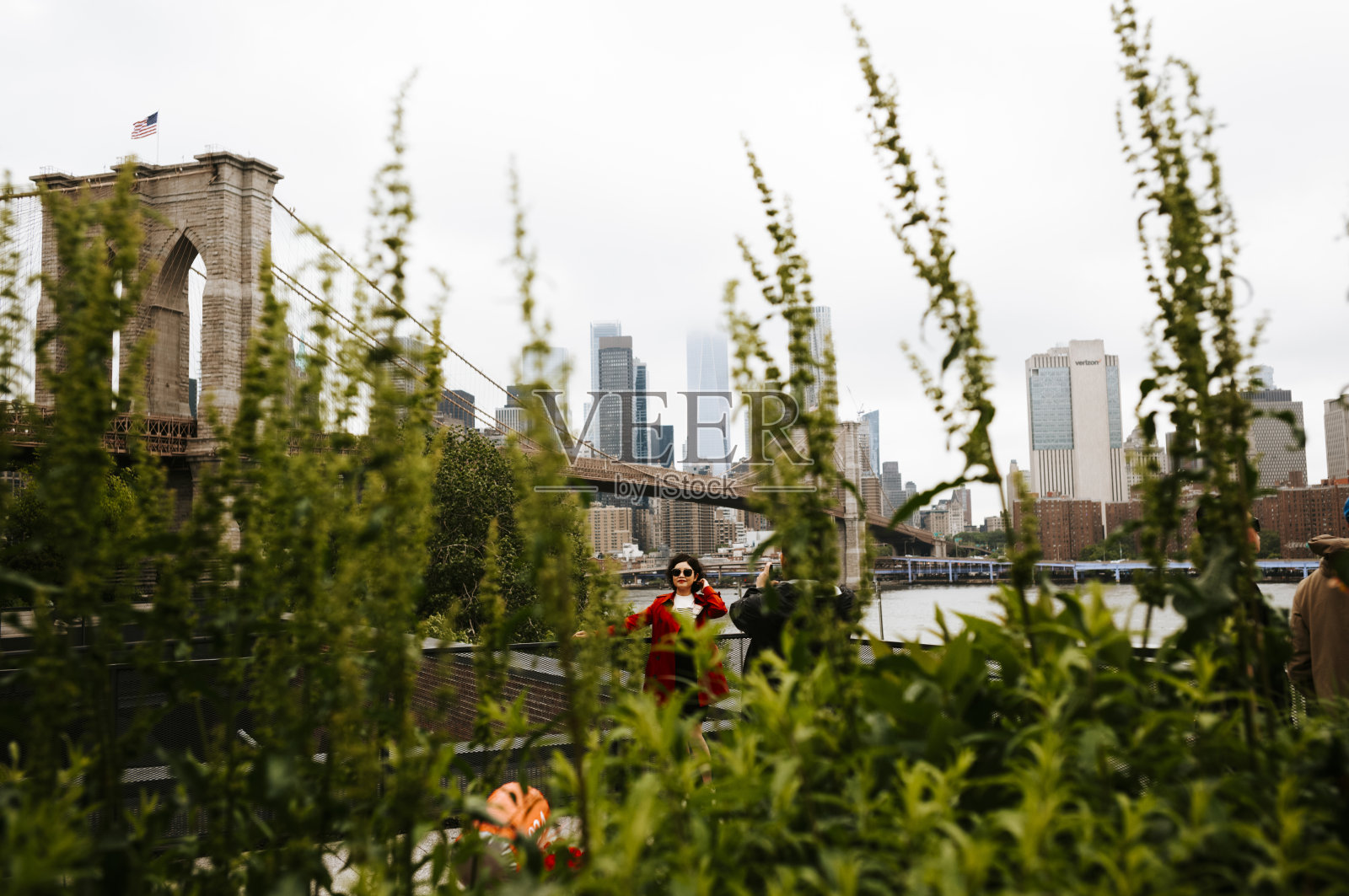 在纽约市布鲁克林大桥前摆姿势的女游客照片摄影图片