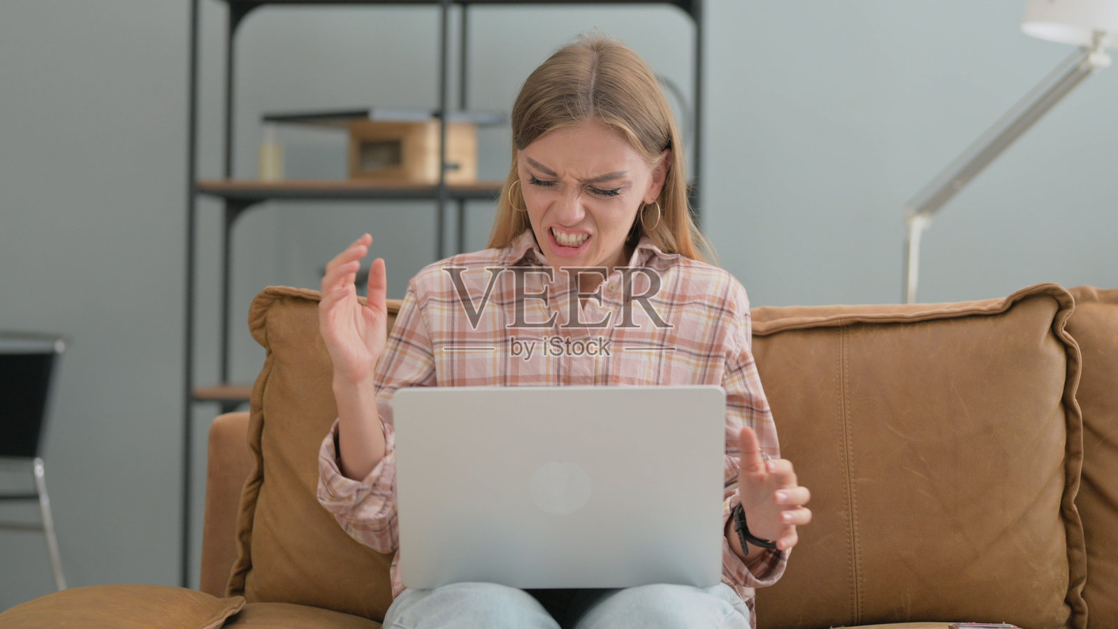 愤怒的年轻女性在使用笔记本电脑照片摄影图片