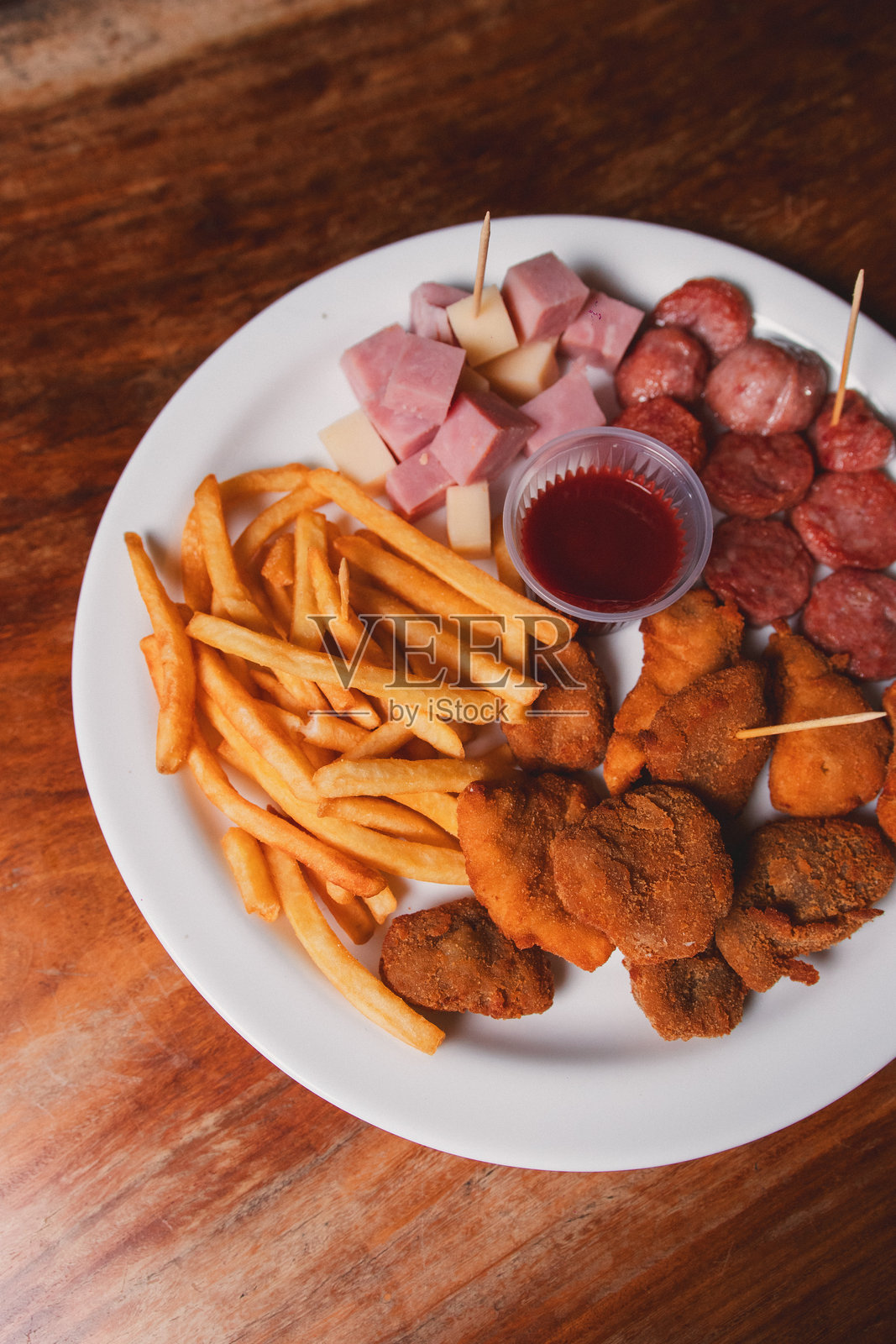 木桌上小盘子里的零食特写。照片摄影图片