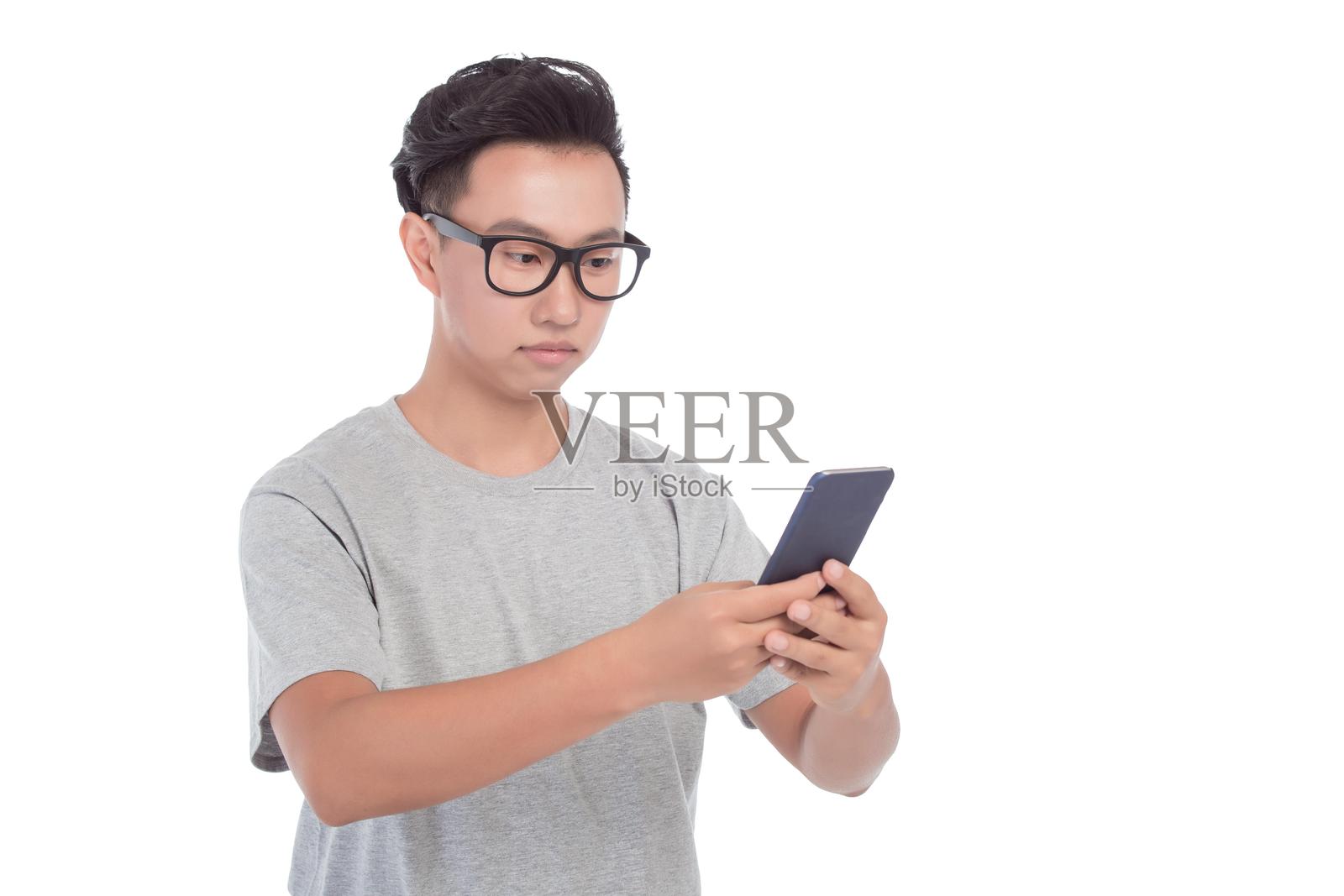 戴眼镜的亚洲男子正在拿着智能手机照片摄影图片