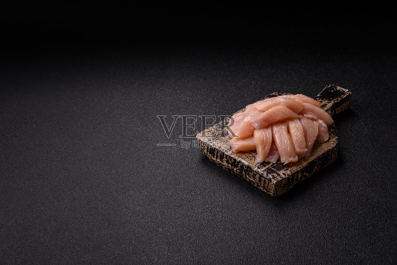 生鸡肉或火鸡肉片切成薄片，撒上盐、香料和草药照片摄影图片