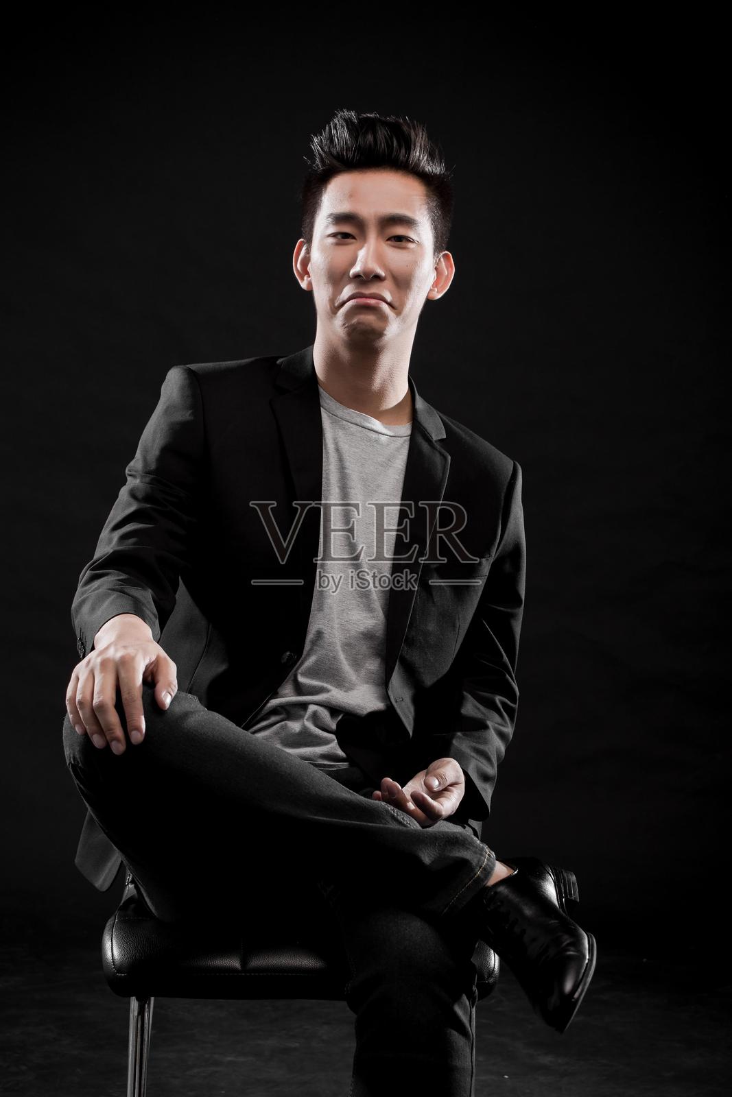 一位年轻亚洲男子穿着西装，面带模糊表情的半身肖像照片摄影图片