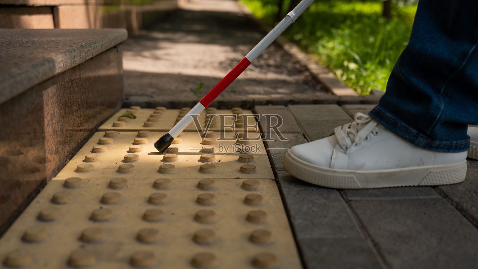 女性脚部特写，手杖和触觉砖。盲人女性使用手杖爬楼梯。照片摄影图片