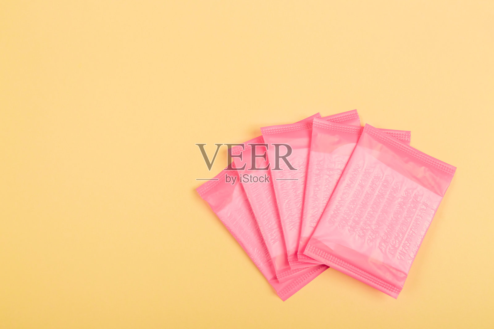 黄色背景上的日常卫生巾，适用于特殊的关键日子。留白。女孩的秘密。俯视图。布局。模板。平铺。样机设计。物品。文本位置。照片摄影图片