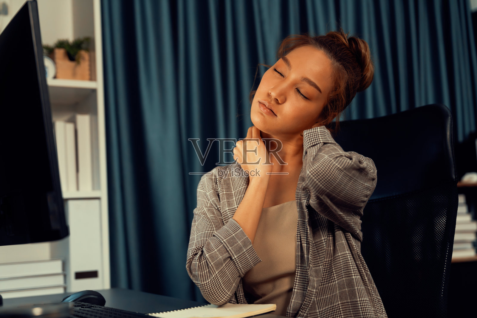 夜间，女商人在电脑前工作，伸展手臂。信息高速公路。照片摄影图片