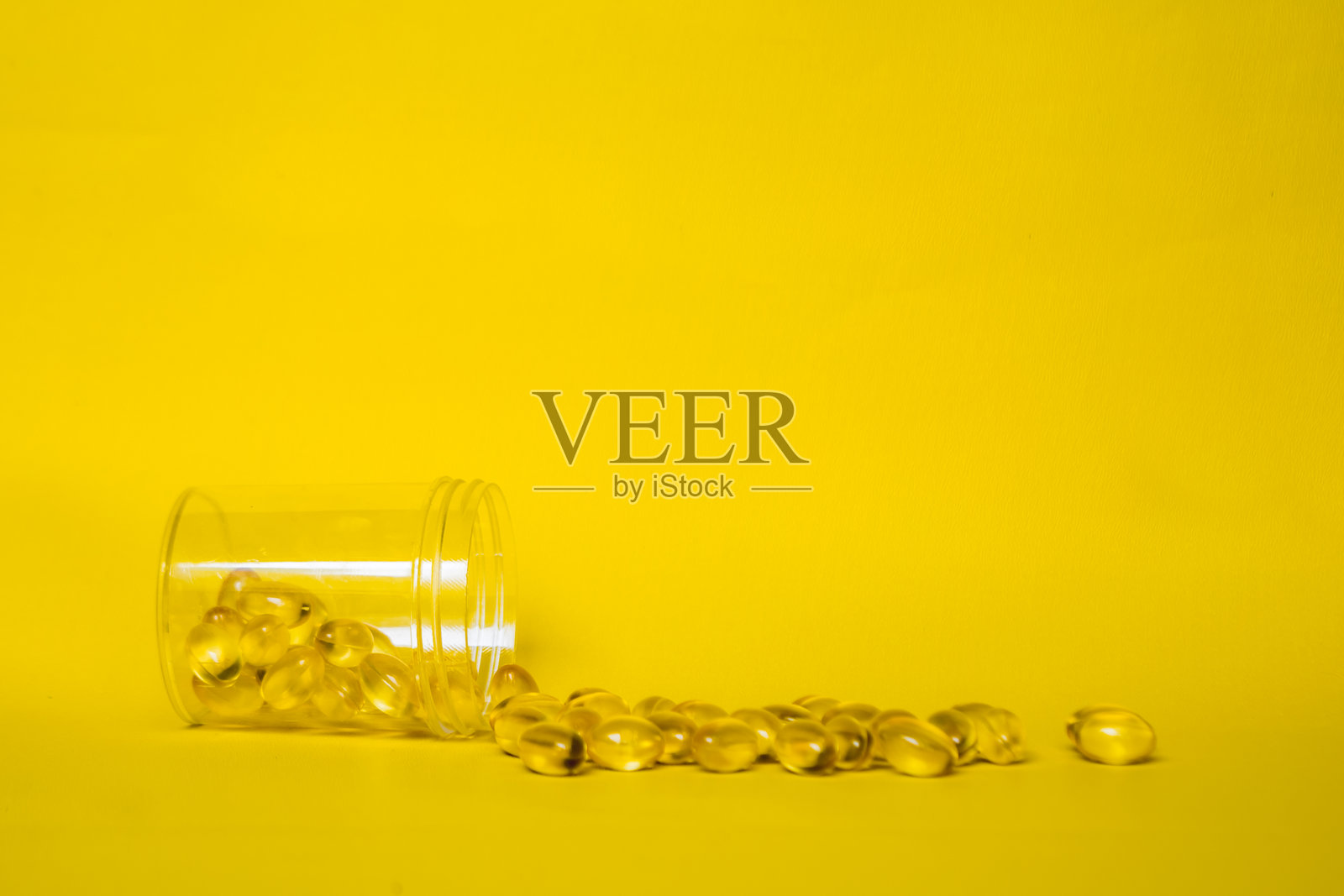 鱼油维生素胶囊从瓶子里洒出来照片摄影图片