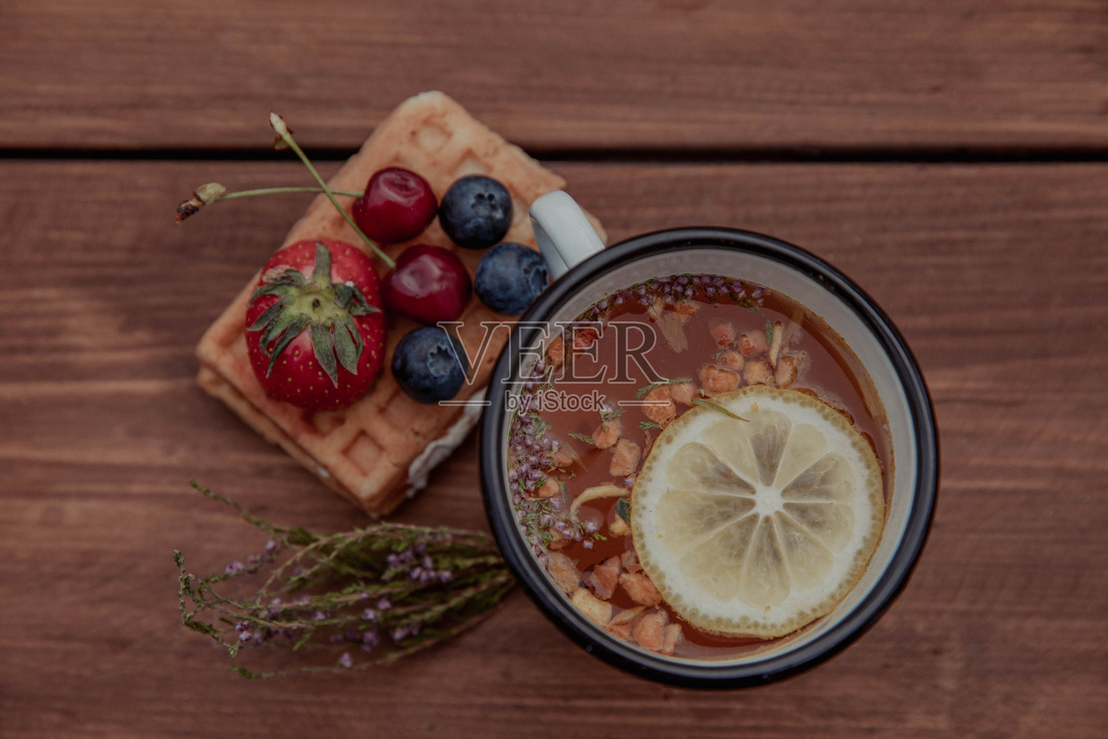 比利时华夫饼配草莓、蓝莓和樱桃，以及柠檬茶照片摄影图片