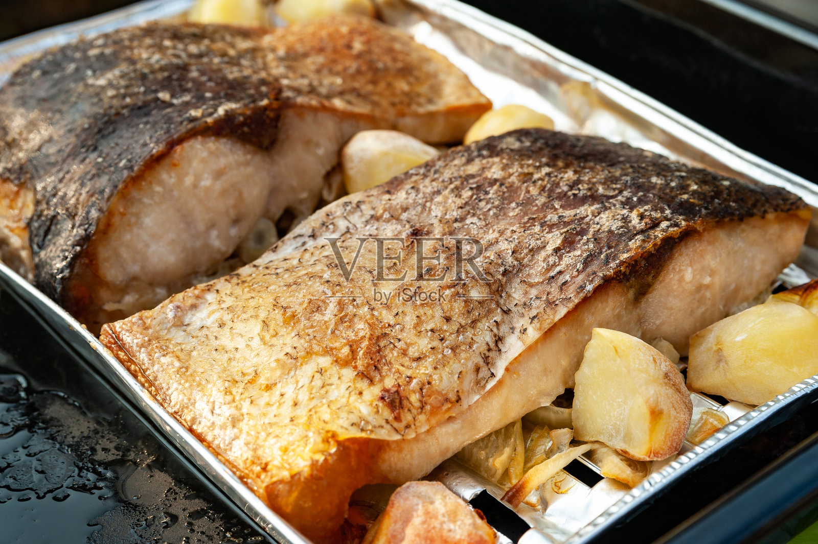 鱼与蔬菜。烤鱼与装饰上的蔬菜。自制美食。自然饮食的概念。照片摄影图片