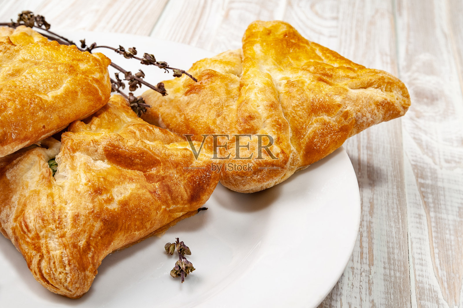 白盘上的新鲜蔬菜馅包子和干香料。白色木桌上的小麦面包与蔬菜馅。照片摄影图片