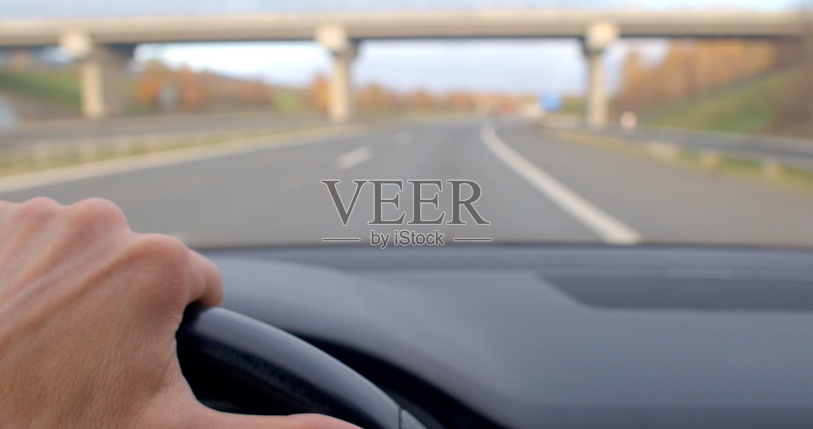 在高速公路上行驶，背景中可见高架桥照片摄影图片