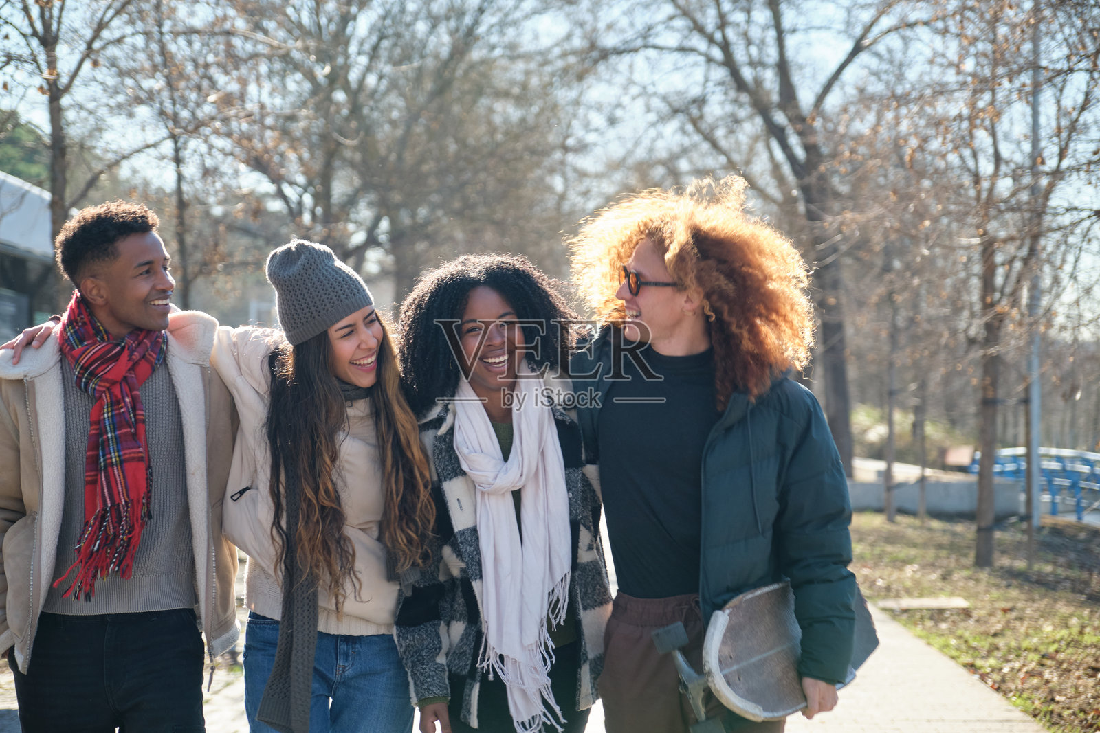 年轻学生在城市公园里一起散步照片摄影图片