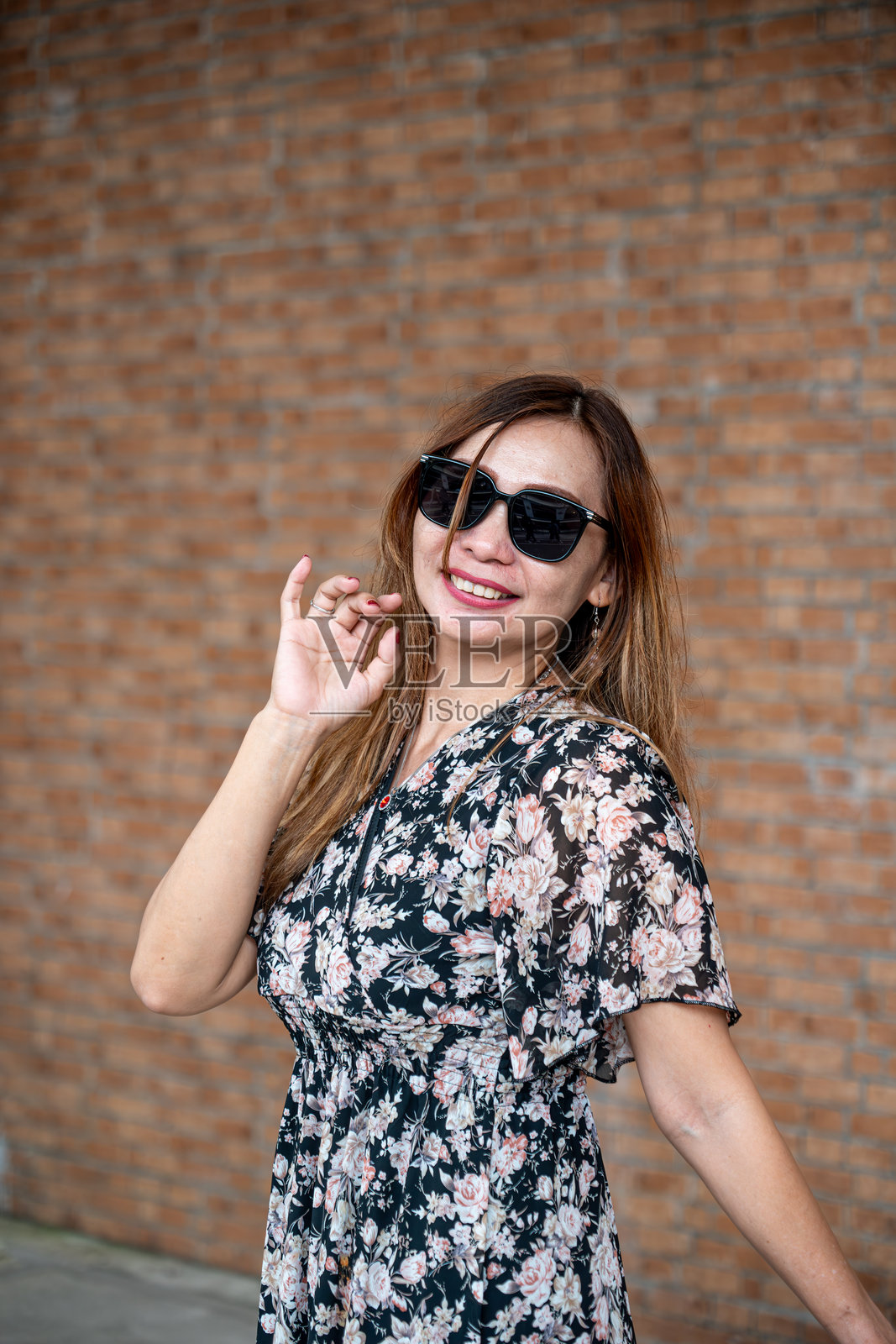 一位美丽的女性戴着太阳镜摆姿势。照片摄影图片