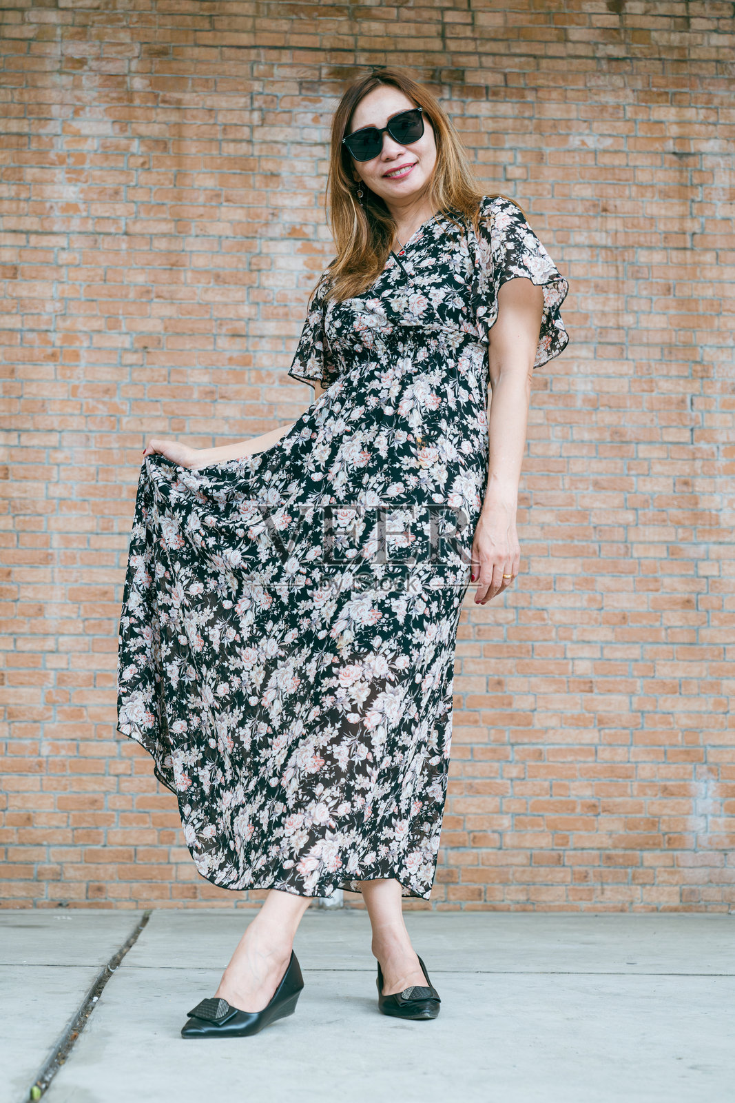 一位美丽的女性戴着太阳镜摆姿势。照片摄影图片