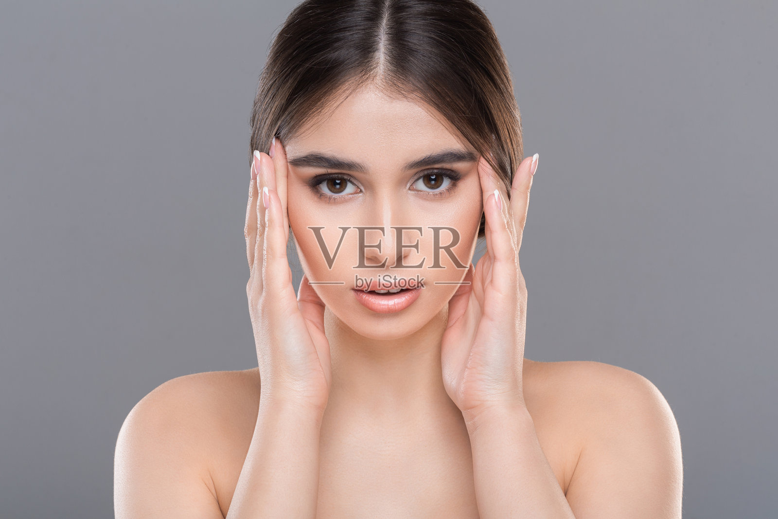 年轻美丽的女性在特写镜头下按摩她的脸部照片摄影图片