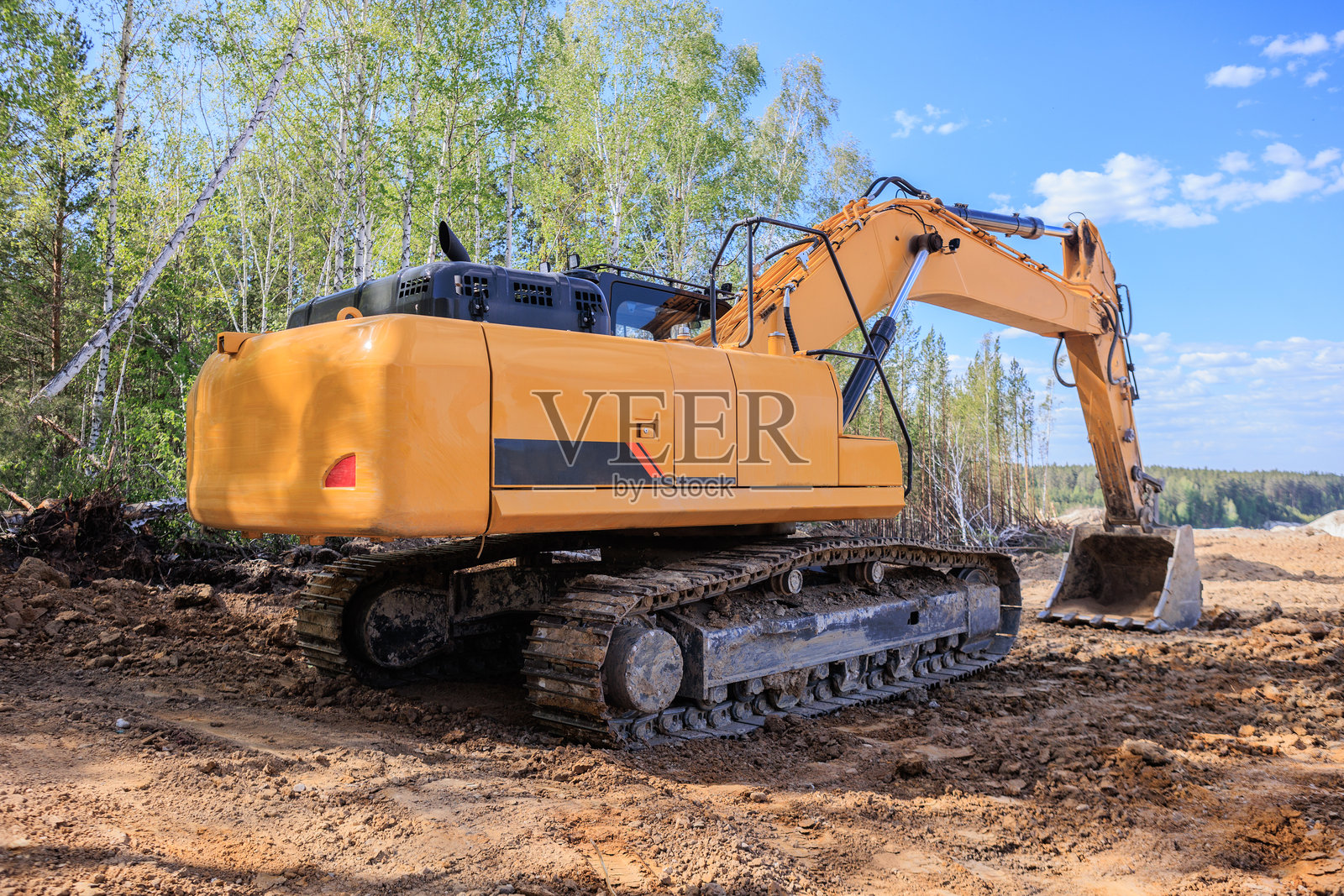 大型挖掘机停在森林附近的地面上照片摄影图片