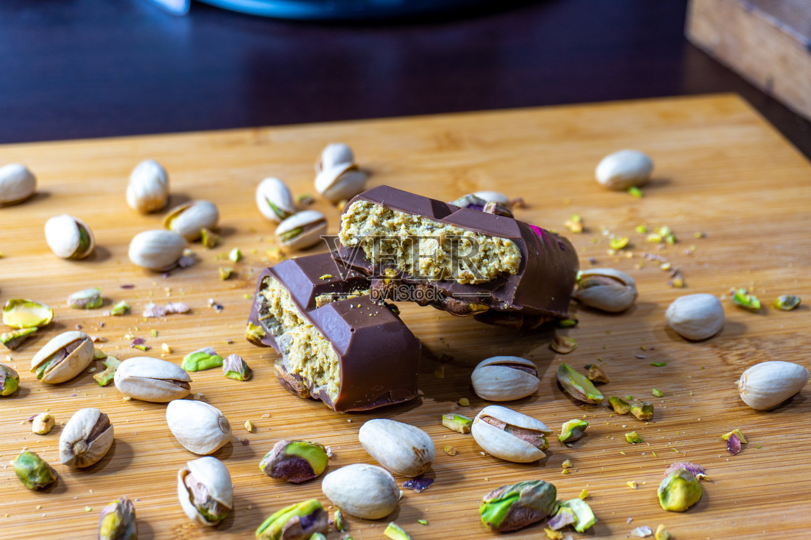 迪拜巧克力棒，搭配绿色卡达伊夫和开心果酱，撒上开心果坚果特写照片摄影图片