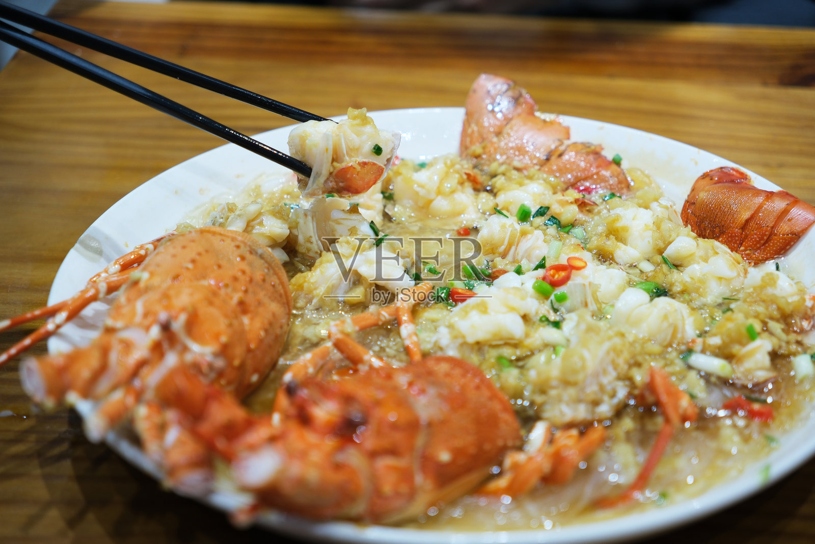 筷子夹起蒸龙虾肉。吃美国龙虾（Homarus americanus）海鲜照片摄影图片