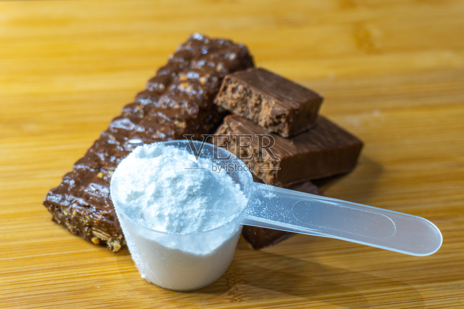 桌子上切开的蛋白质棒和一个蛋白质勺照片摄影图片