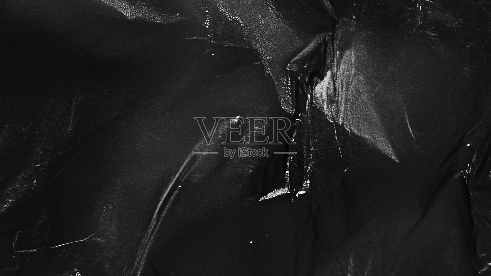 黑色透明塑料薄膜纹理叠加背景。用于海报设计和照片叠加效果的真实塑料。皱褶塑料表面图案，适用于图形设计素材和元素模型。照片摄影图片