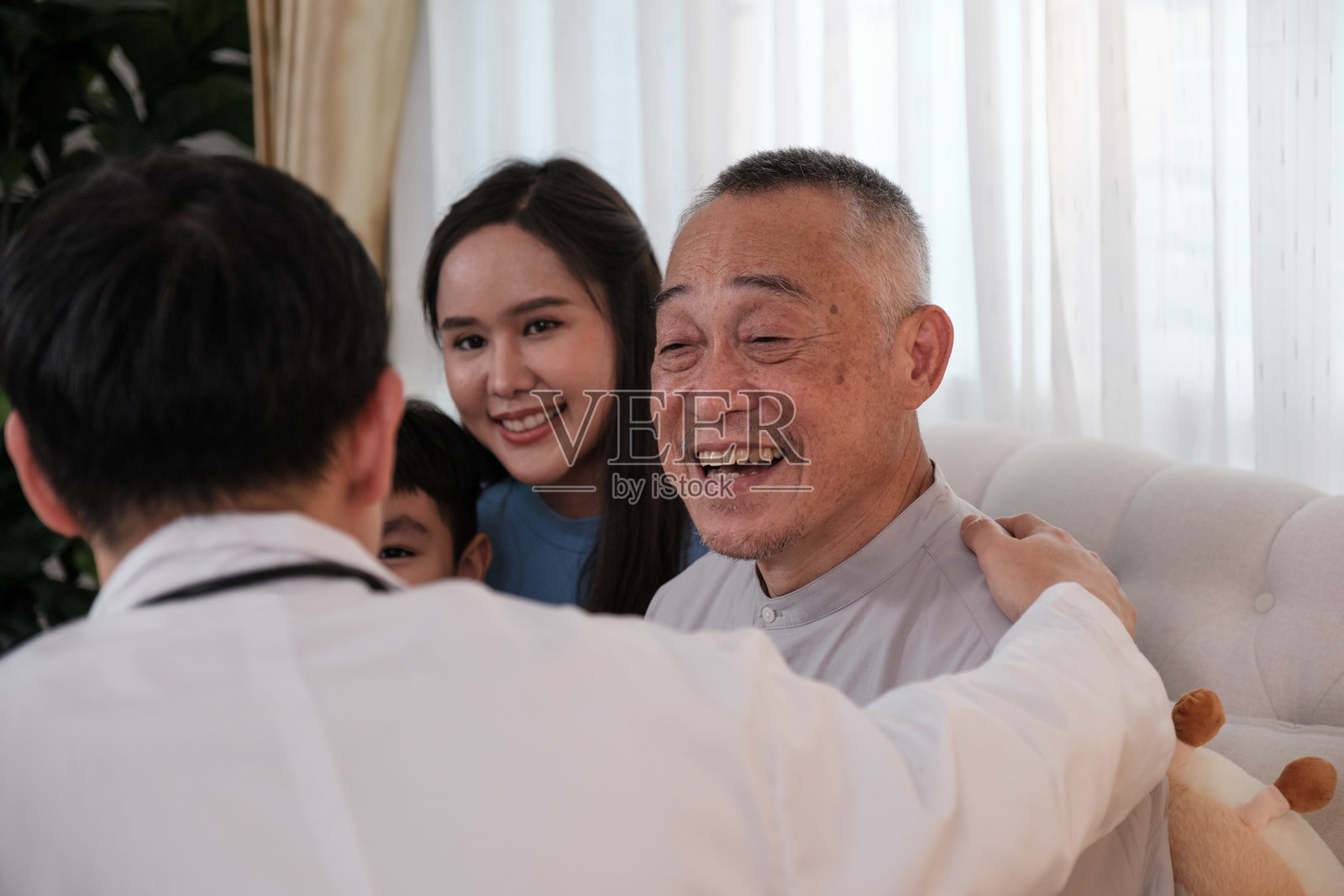 医生为一位亚洲祖父、女儿和孙子进行健康检查。照片摄影图片