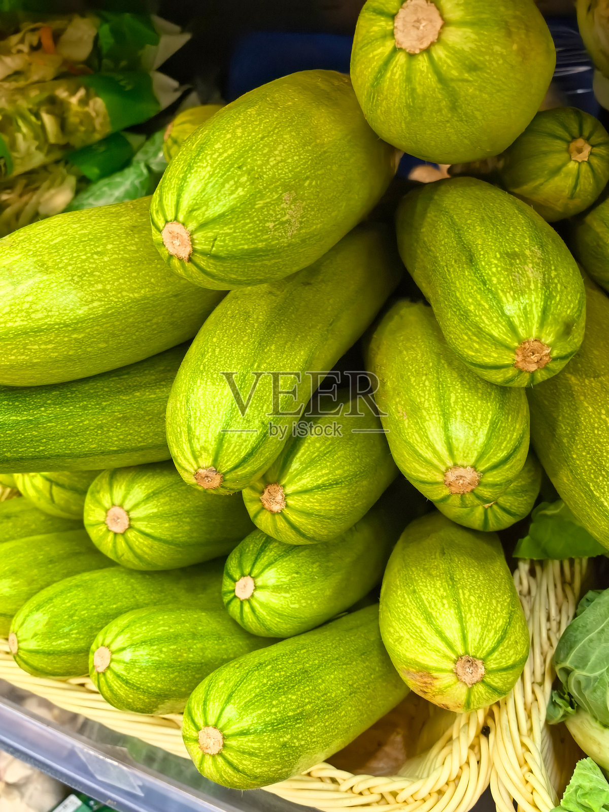 新鲜的绿色西葫芦在生动的市场展示中美丽地堆叠着照片摄影图片