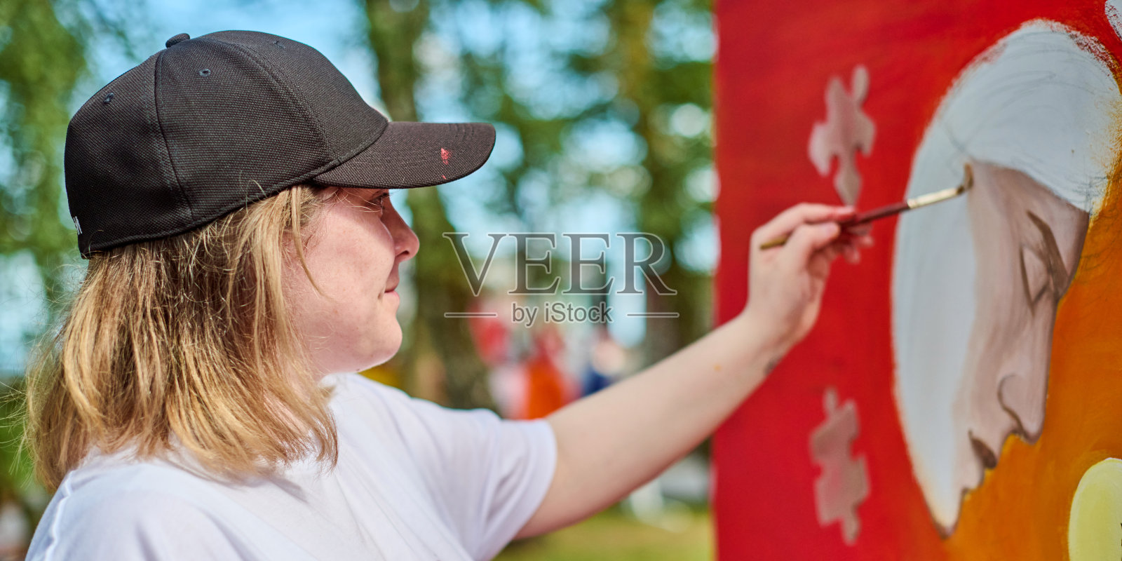 年轻女性艺术家在户外艺术节上作画照片摄影图片