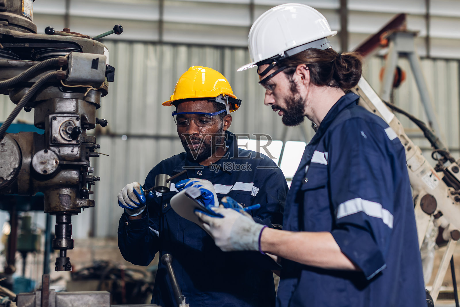 工人在工厂现场检查机器或产品。工头或技术员在工厂检查材料或机器。重工业工厂概念。照片摄影图片
