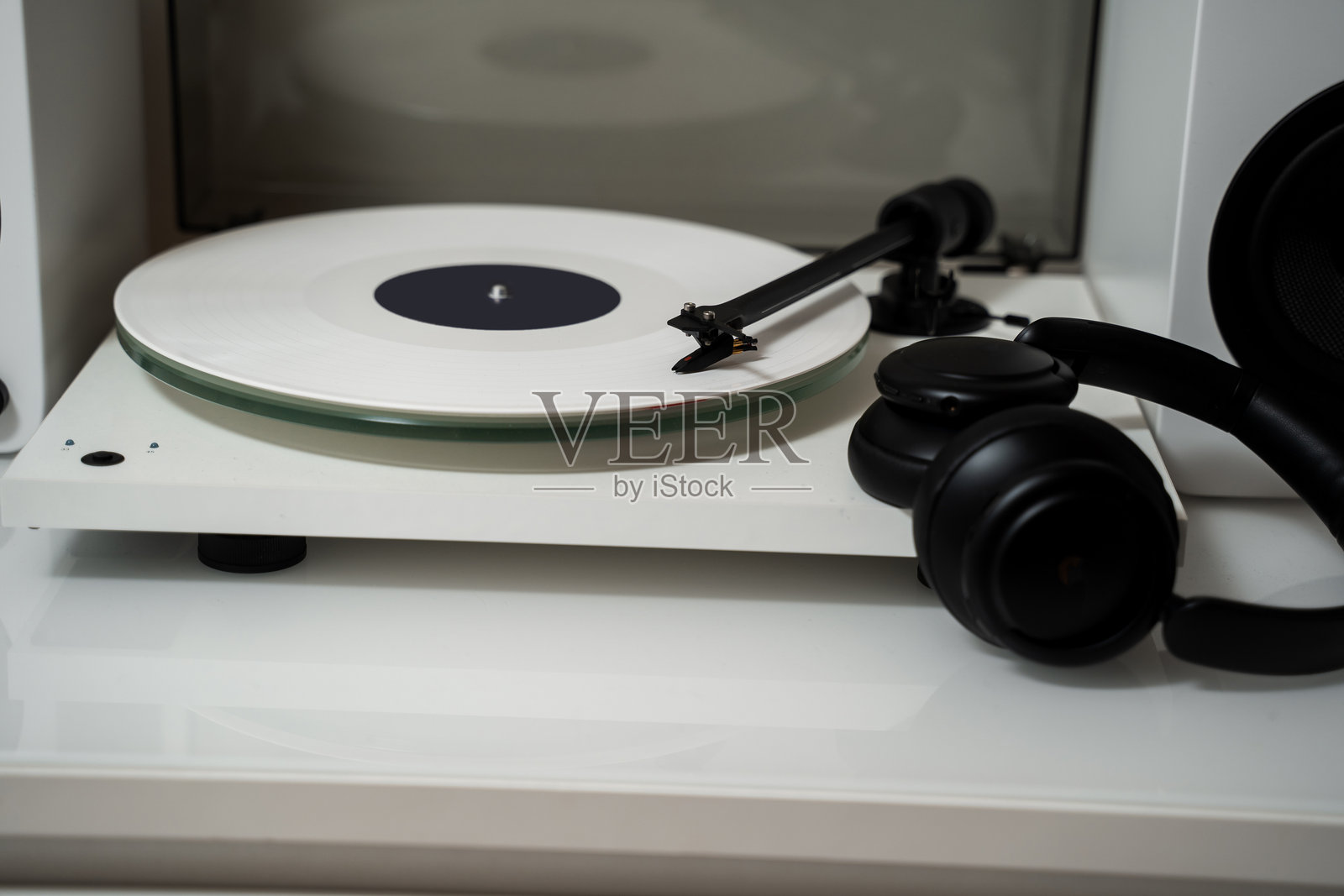 在音响系统上享受高保真音乐。33转白色黑胶唱片在唱针播放器上，配有耳机音响。照片摄影图片