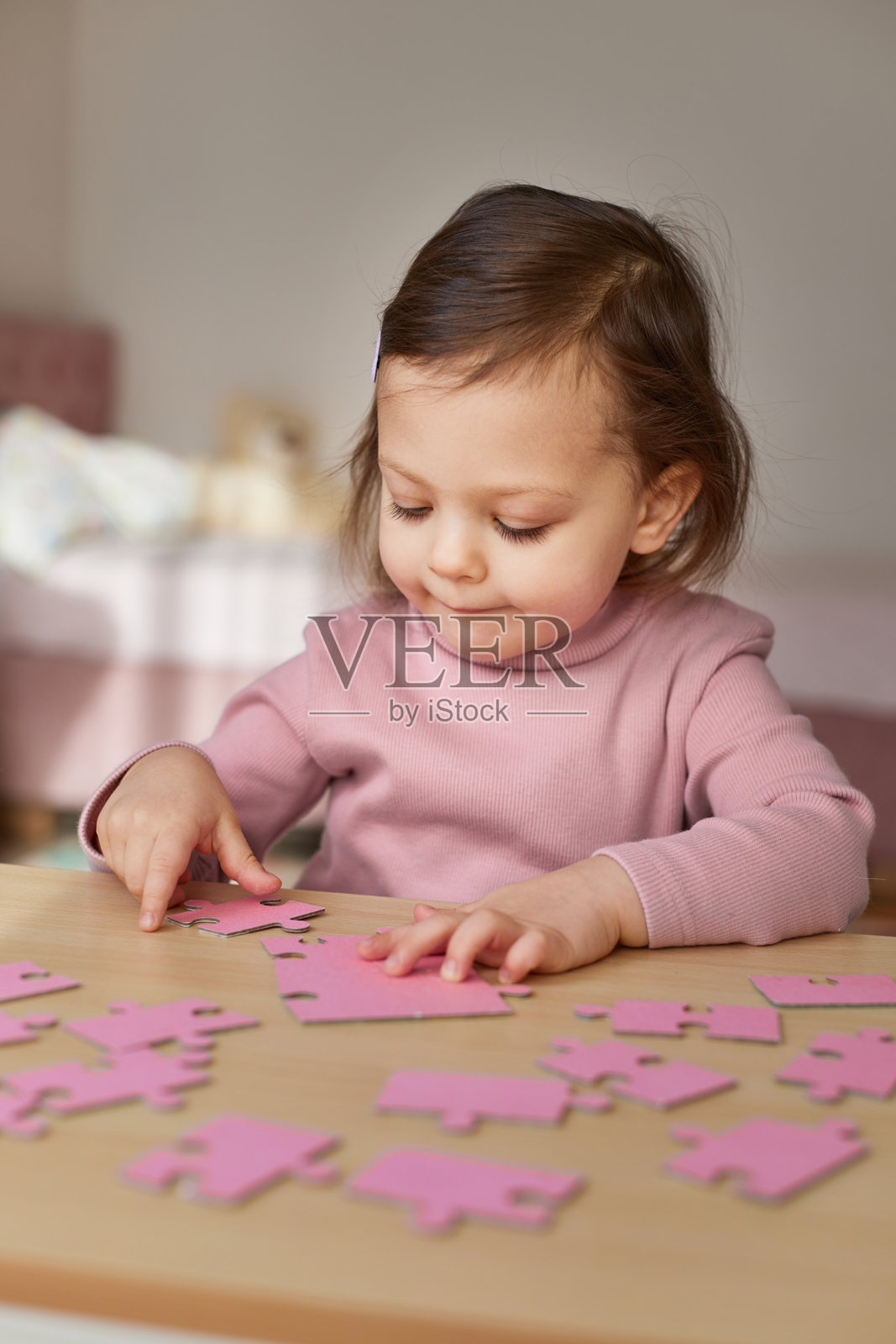 孩子在房间的木桌上拼接拼图块照片摄影图片