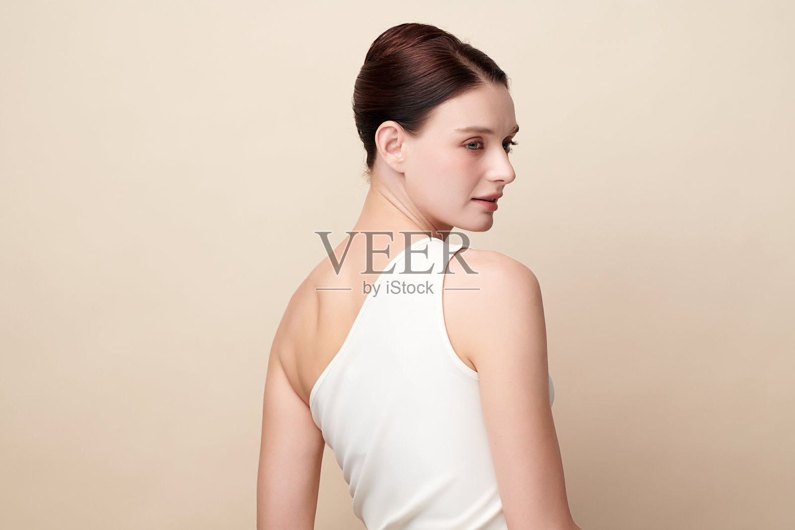 美丽的年轻女性，肤色洁净清新，背景为米色，面部护理，面部治疗，美容学，美容与水疗，女性肖像。照片摄影图片