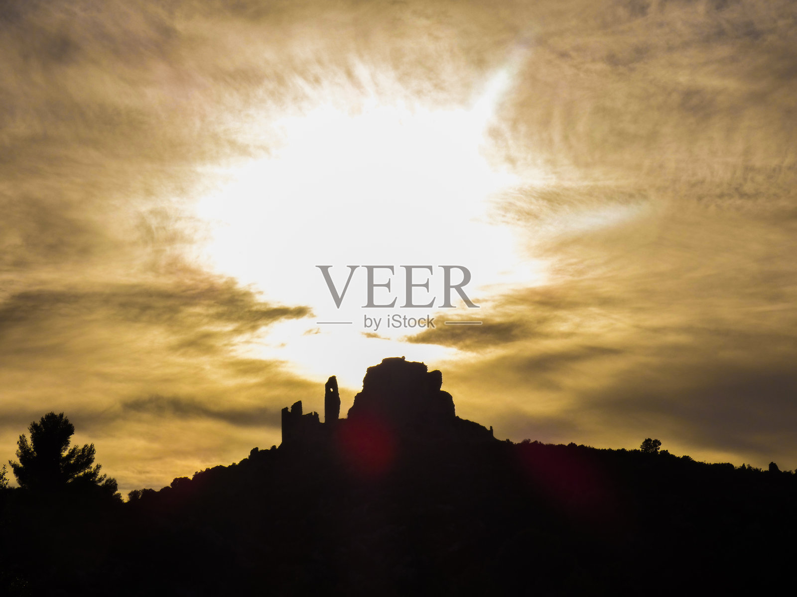 在法国普罗旺斯阿尔皮勒地区埃吉埃尔附近的让娜女王城堡上，夕阳将天空和云层完全照亮，这是一幅壮丽的景色照片摄影图片