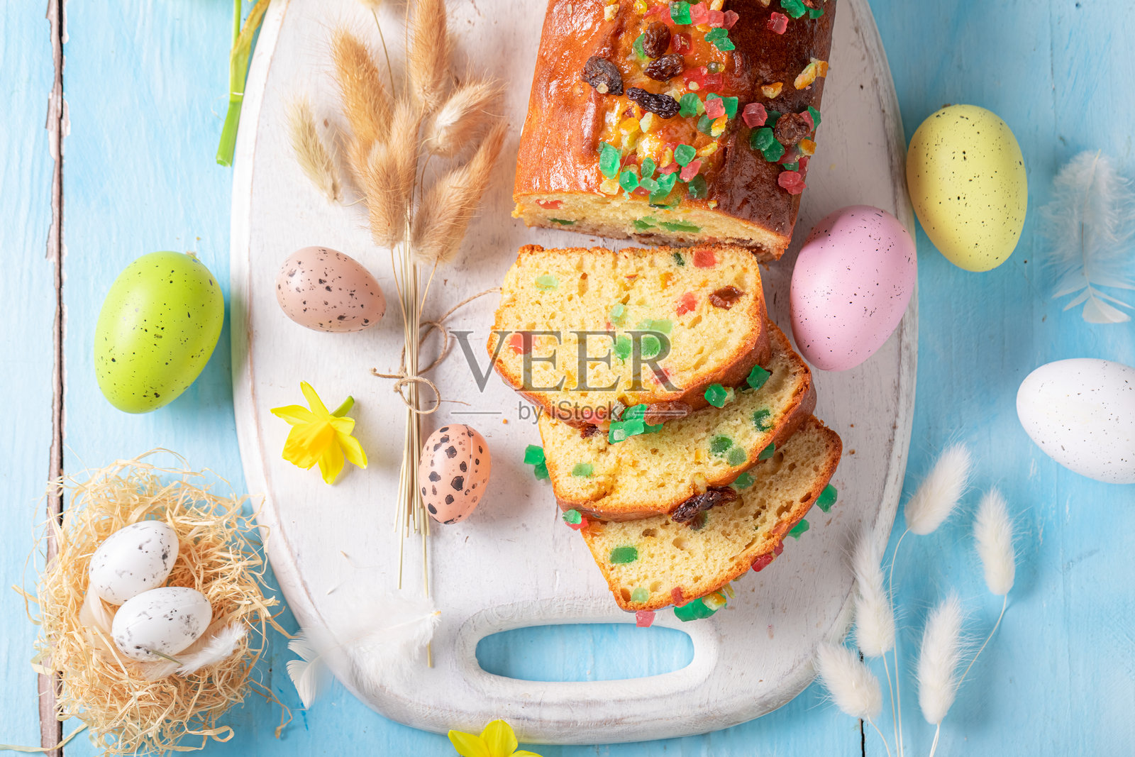 复活节的传统水果蛋糕，周围环绕着春天的花朵和鸡蛋。照片摄影图片