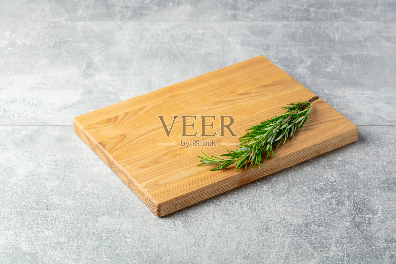 石桌上的砧板和迷迭香。照片摄影图片