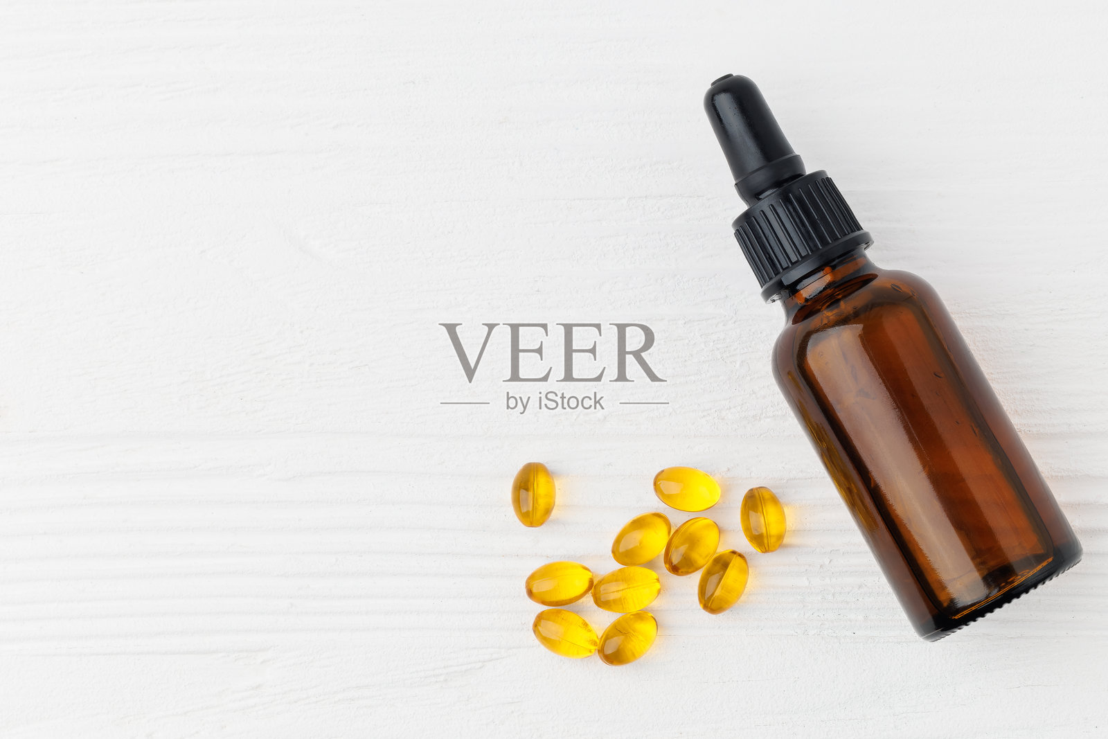 白色木桌上的D3维生素瓶和油软凝胶胶囊，俯视图照片摄影图片