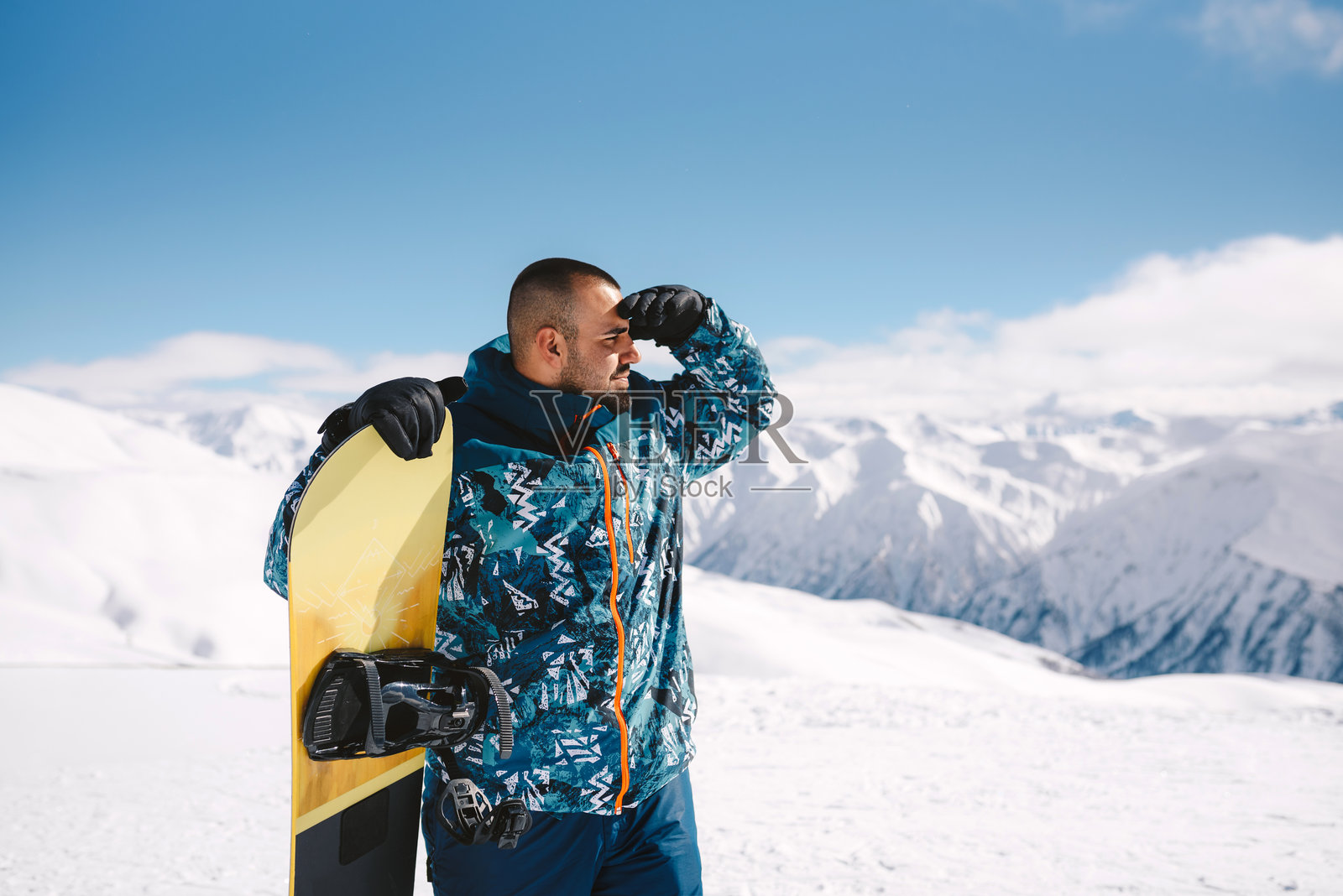 雪山中的年轻男子与滑雪板。照片摄影图片