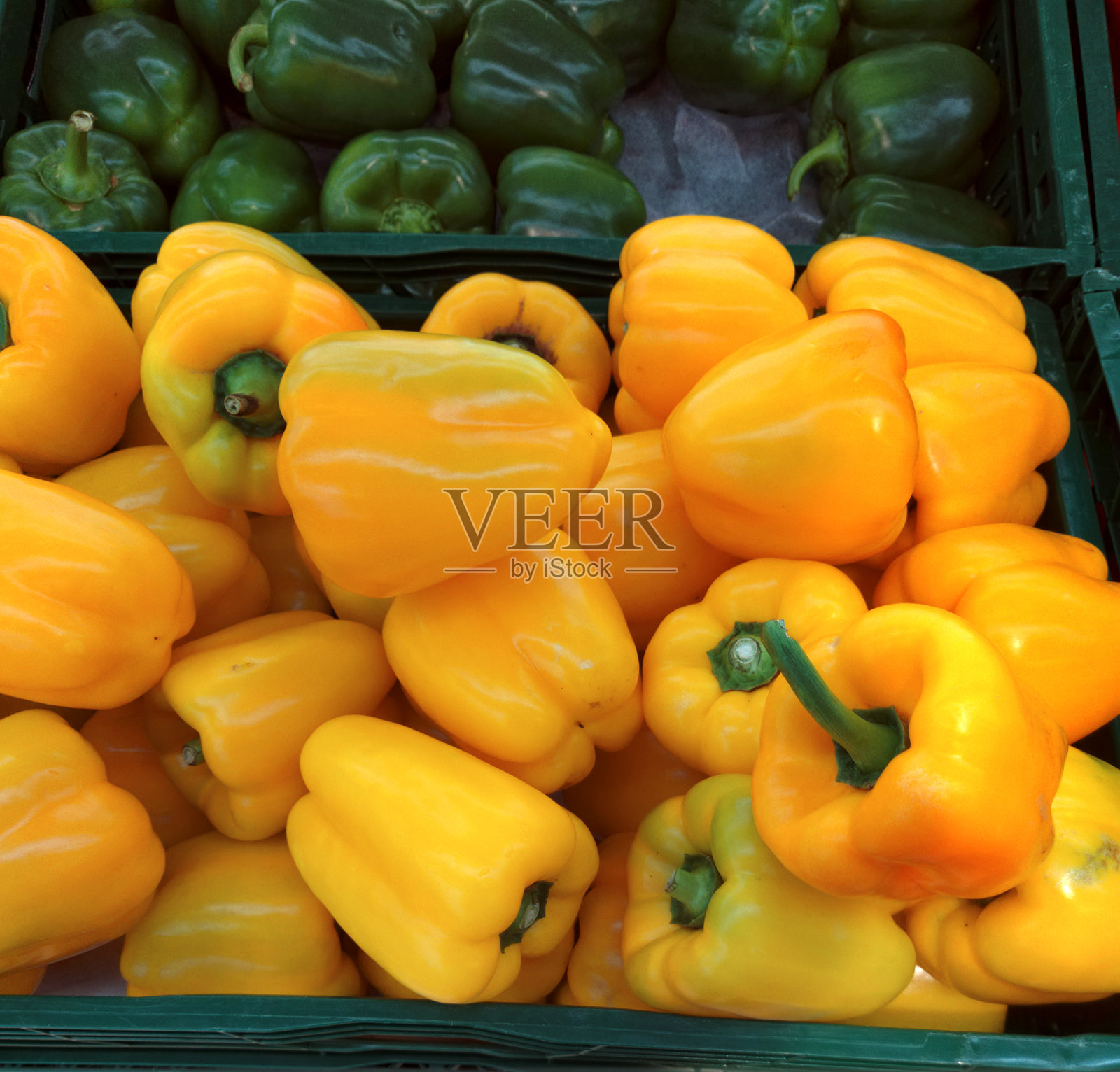 新鲜的彩椒装在一个分隔的盒子里。明亮的黄色椒子填满了一个优先区域。照片摄影图片