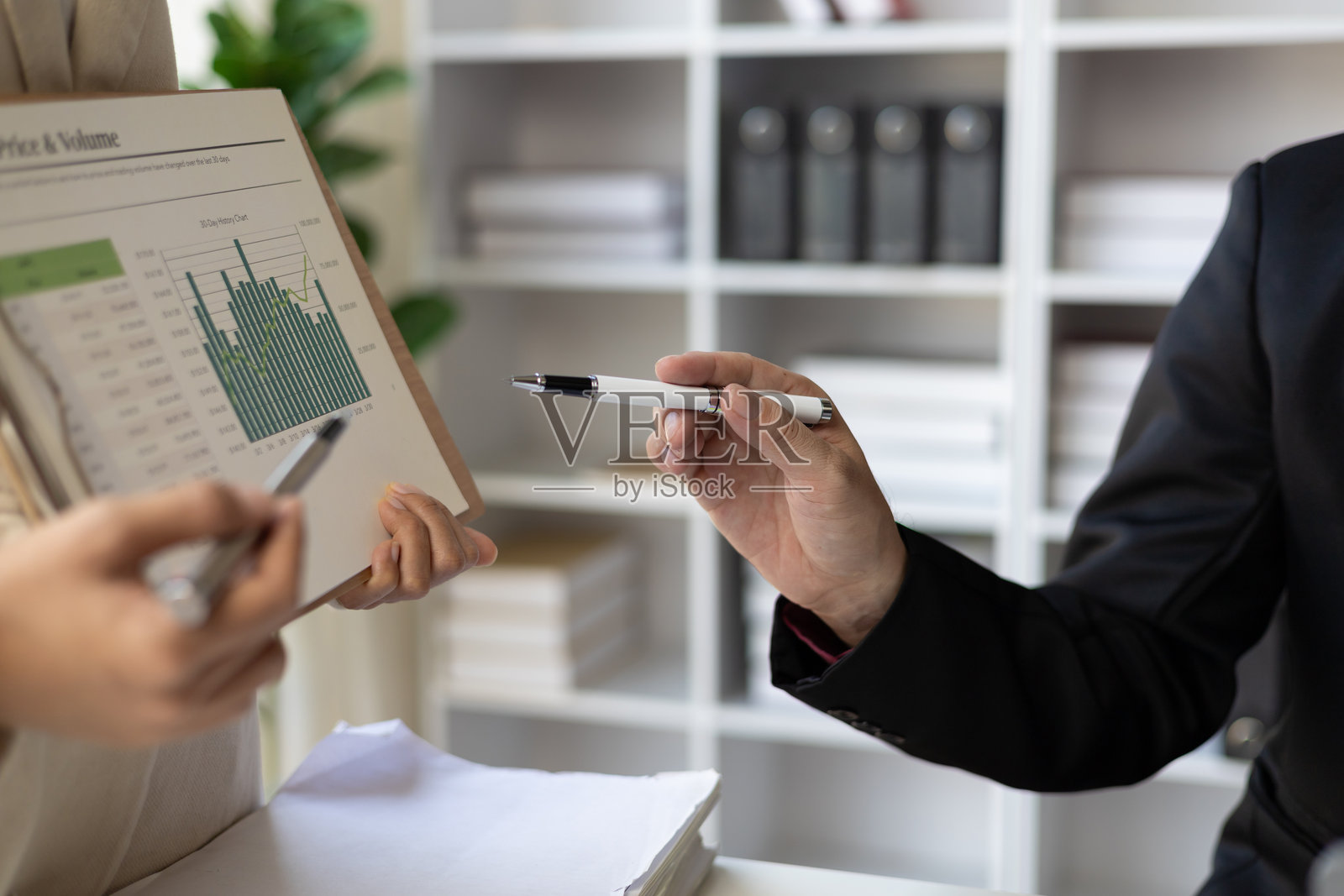 会议通过分析公司报告中的财务图表讨论商业状况，以分析策略并规划新的投资项目以增加利润。照片摄影图片