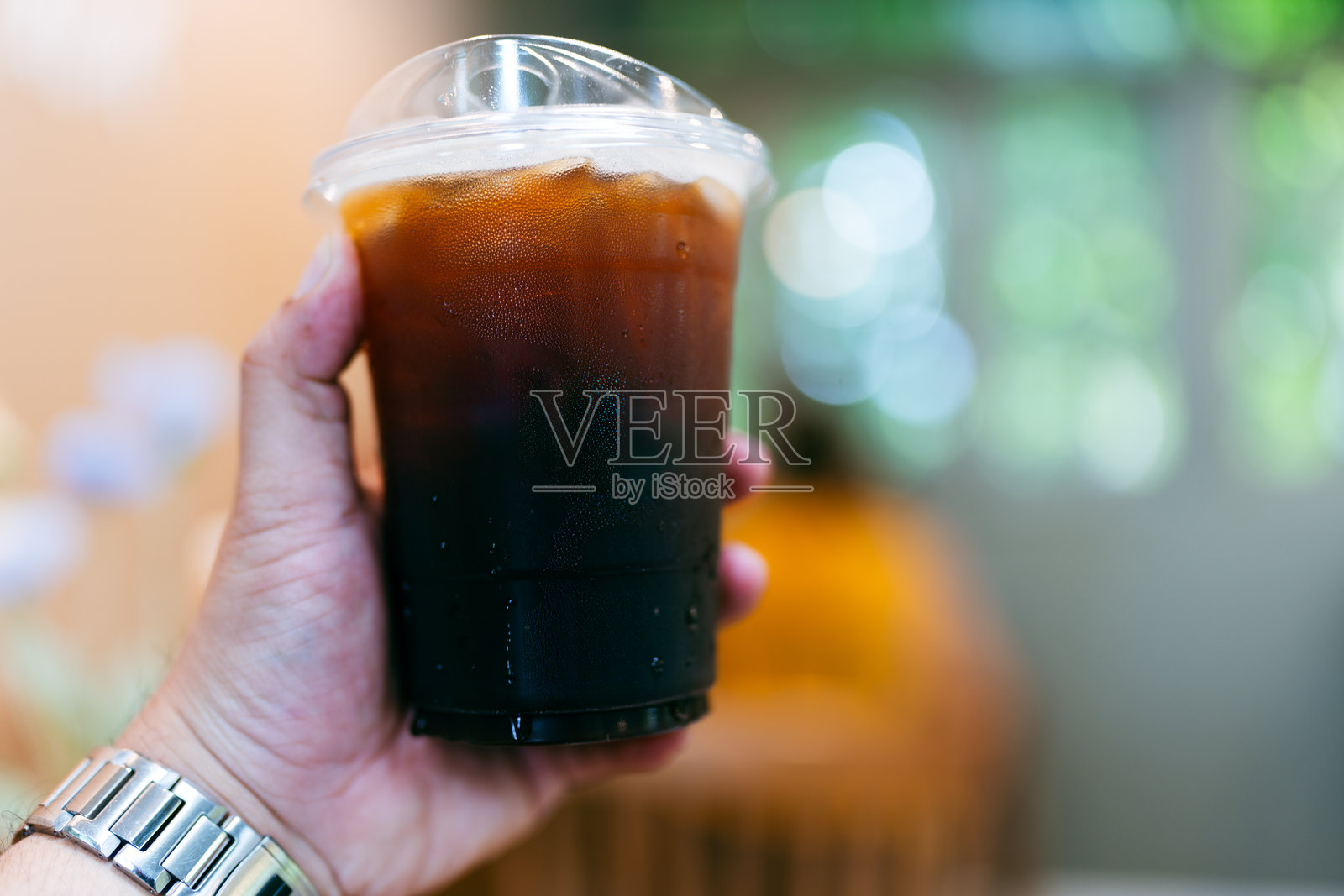 特写塑料外卖杯装冰黑咖啡照片摄影图片