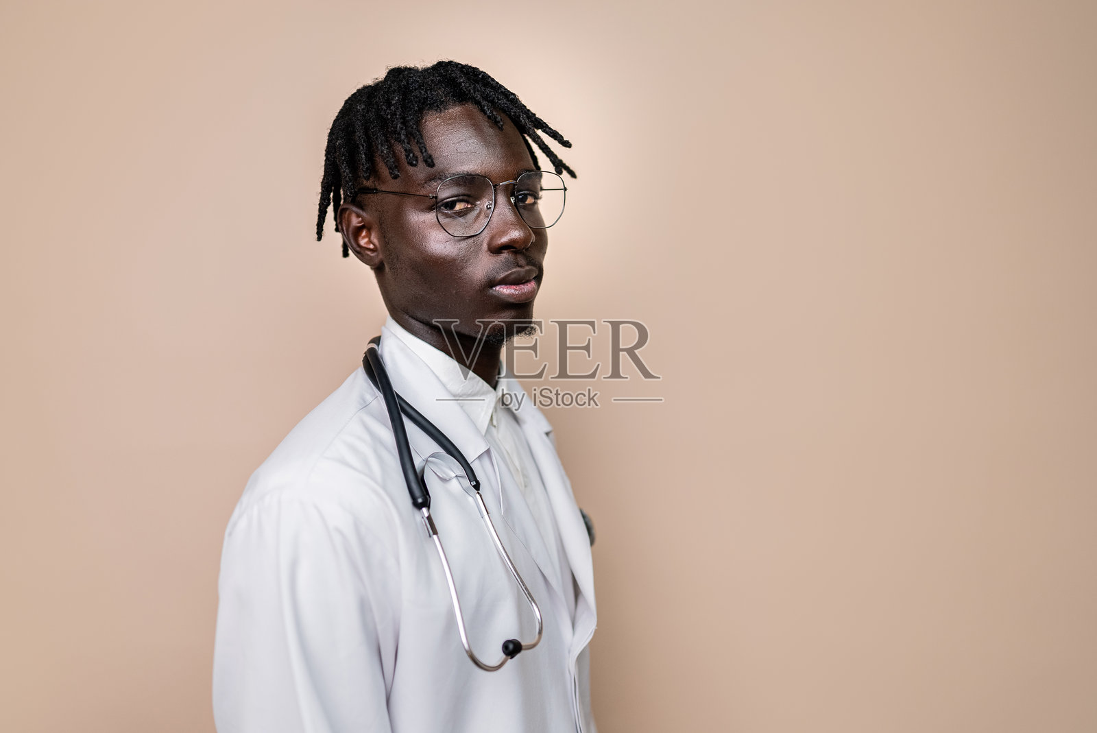 年轻医生的肖像，背景为米色照片摄影图片