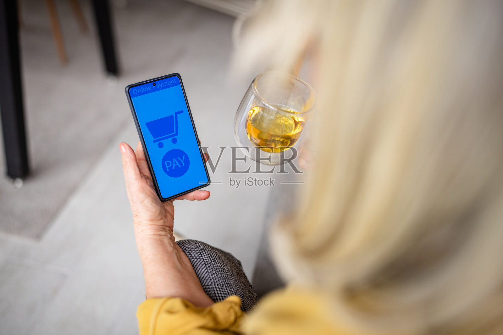 在家中享受安静时光的老年女性，使用智能手机进行在线购物和支付照片摄影图片