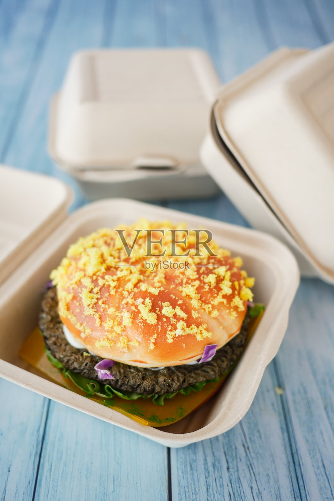 享受美味的奶酪汉堡，采用环保和可持续包装。照片摄影图片