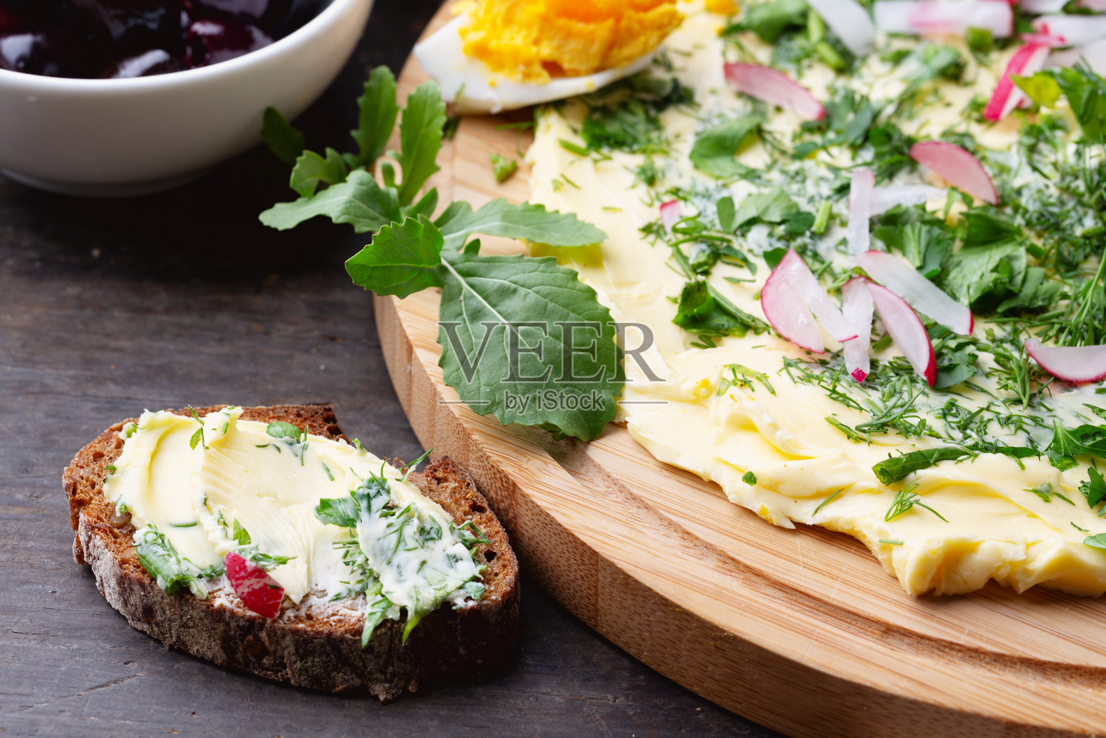 绿色黄油板配新鲜香草、面包片和萝卜照片摄影图片