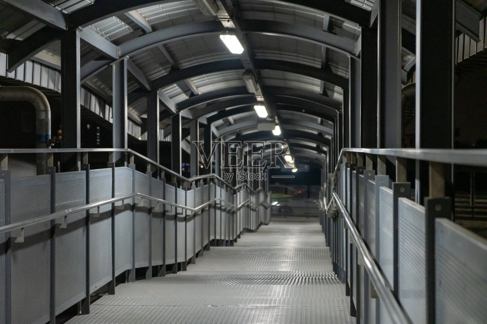 夜间的行人桥，金属人行道和拱形上方结构照片摄影图片