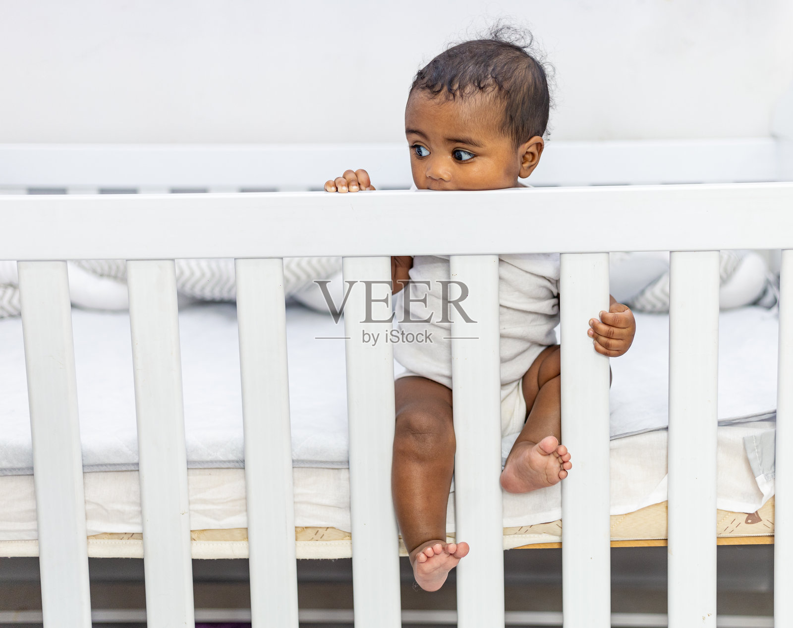 可爱漂亮的非洲小女孩在家里的婴儿床上。照片摄影图片