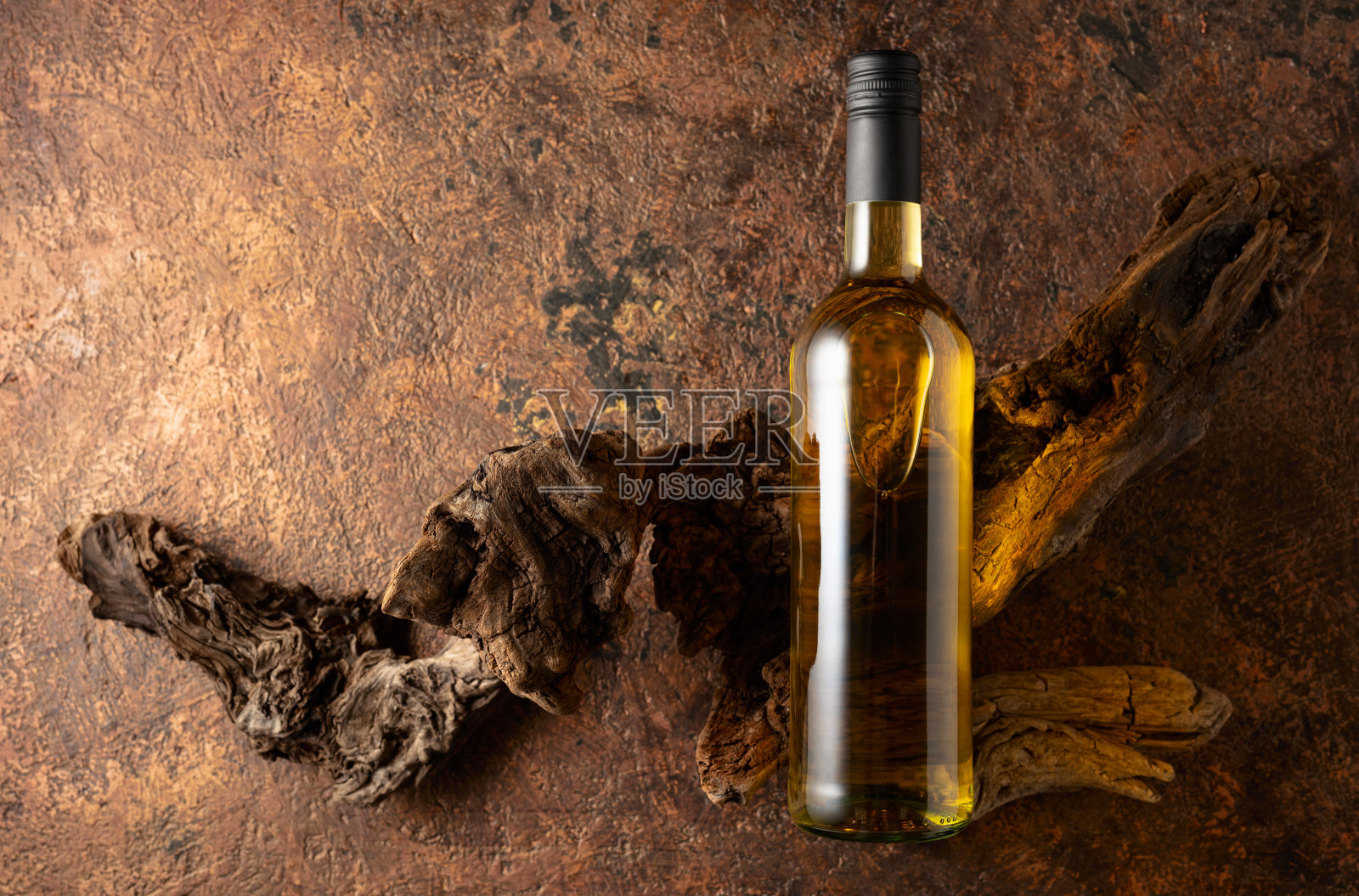 一瓶白葡萄酒和古老的风化木头在棕色复古背景上。照片摄影图片
