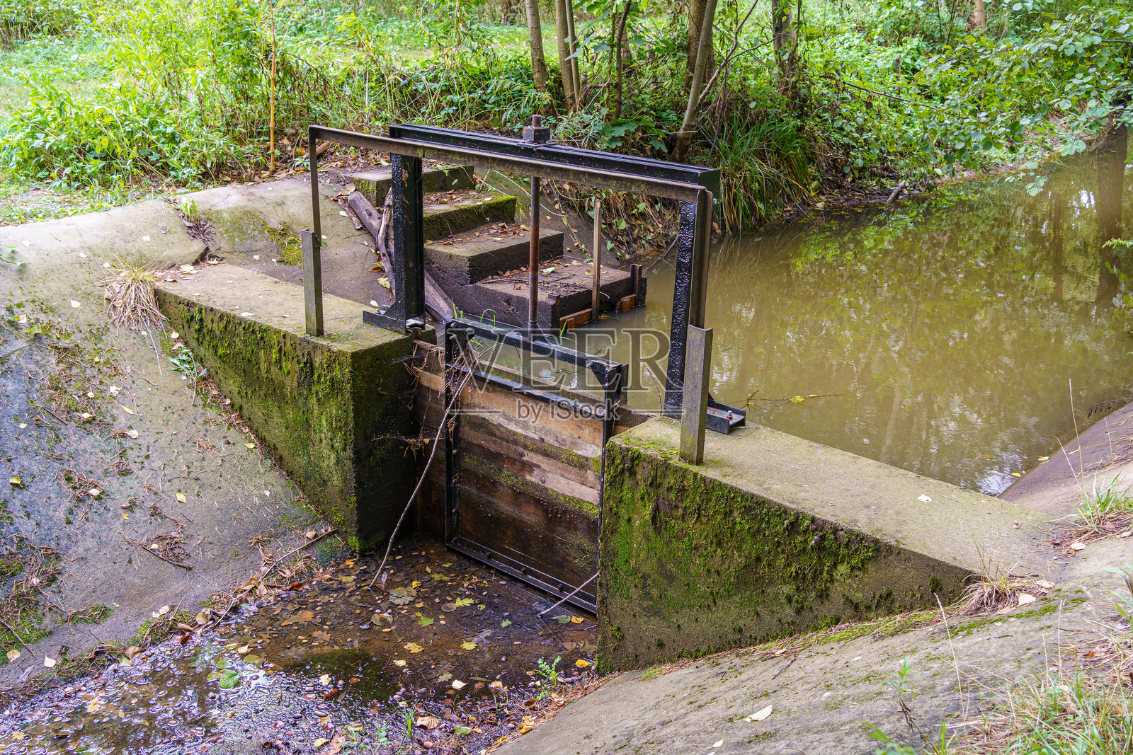 小水渠上的可调节木制挡水板与混凝土堰坝照片摄影图片